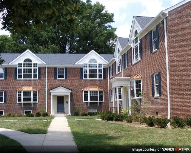 a large brick house with a sidewalk in front of it