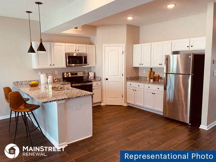 a kitchen with stainless steel appliances and white cabinets