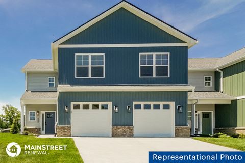 a blue house with two garage doors