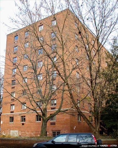 a tall brick building with trees in front of it