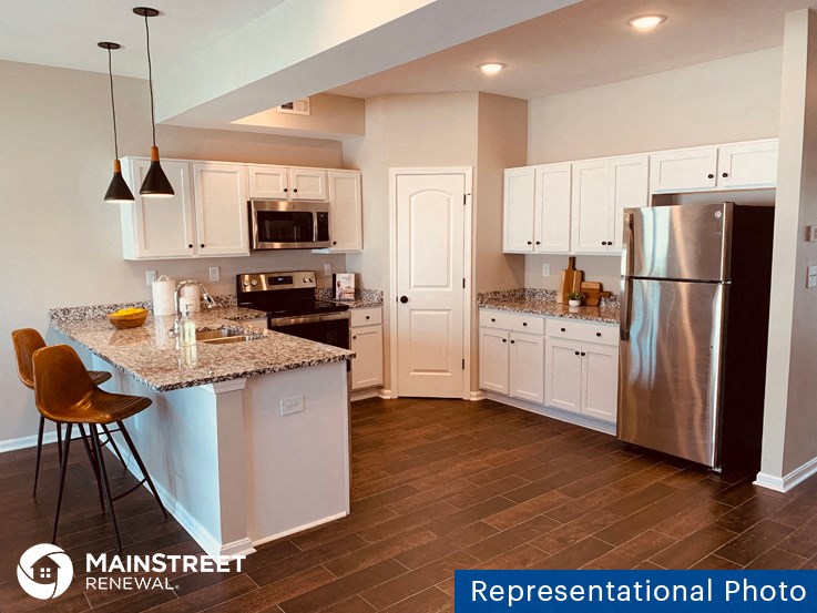 a kitchen with stainless steel appliances and white cabinets