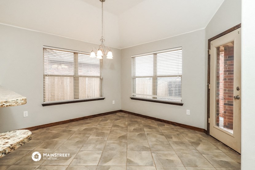 an empty living room with two windows and a door