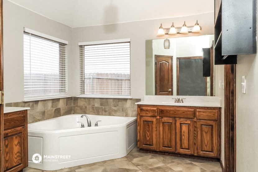 a bathroom with a tub and a sink and a mirror