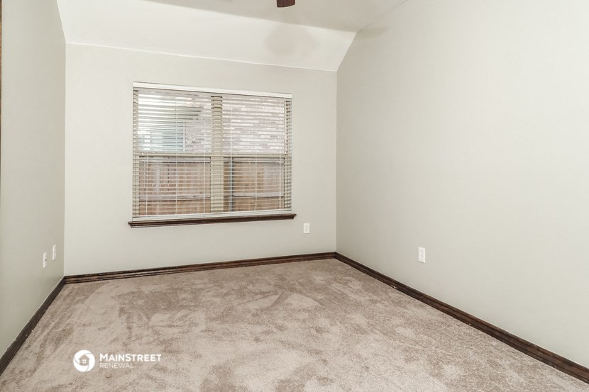 the spacious living room with a large window and carpet