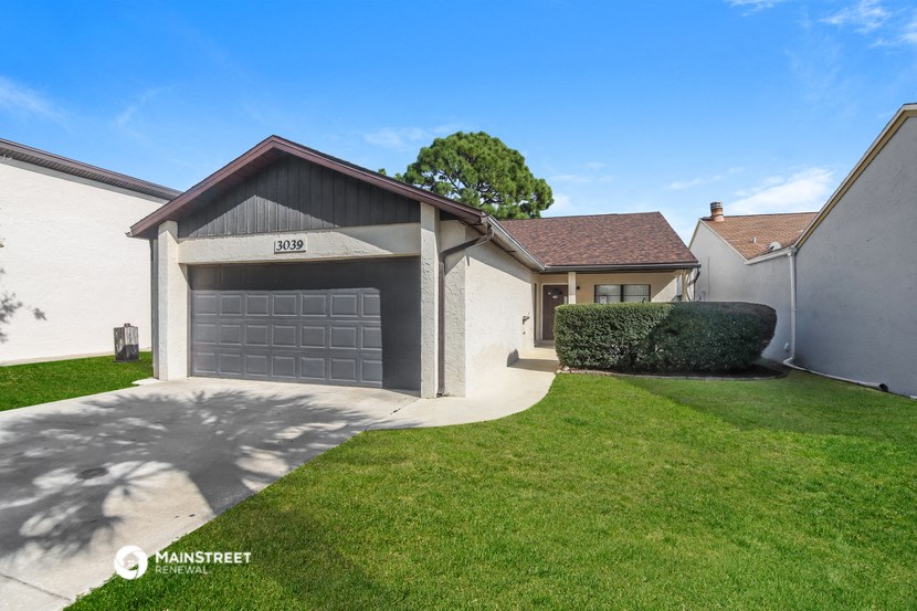 a white house with a garage and a green lawn