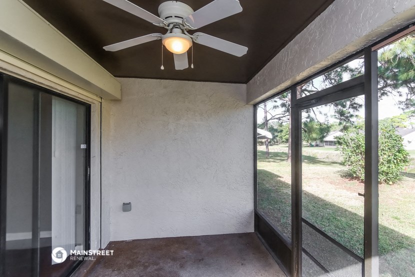a living room with a ceiling fan and a window