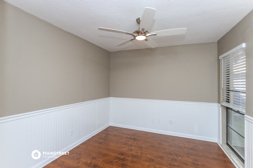 an empty room with a ceiling fan and a window