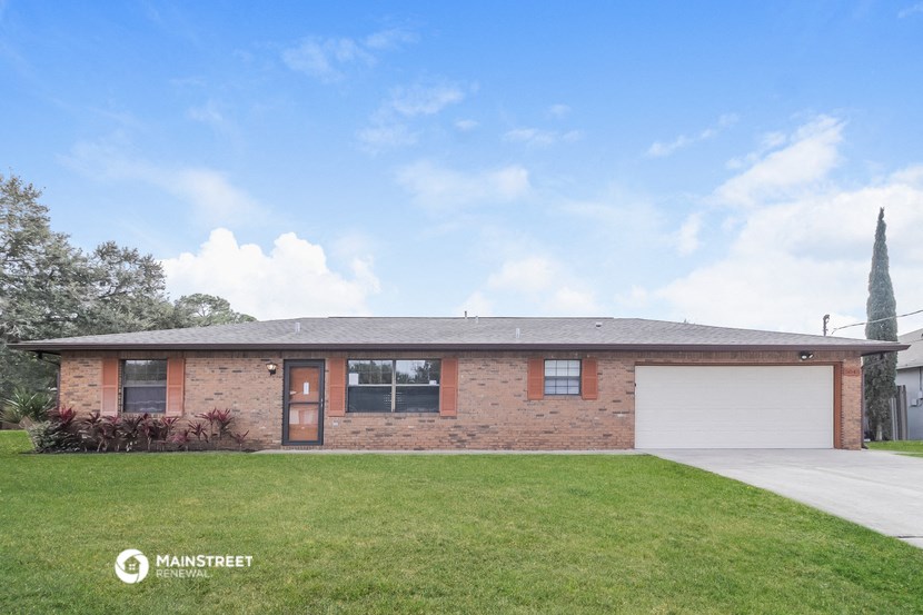 a brick house with a lawn in front of it