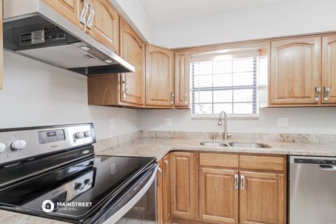 a kitchen with wooden cabinets and a stove and a sink
