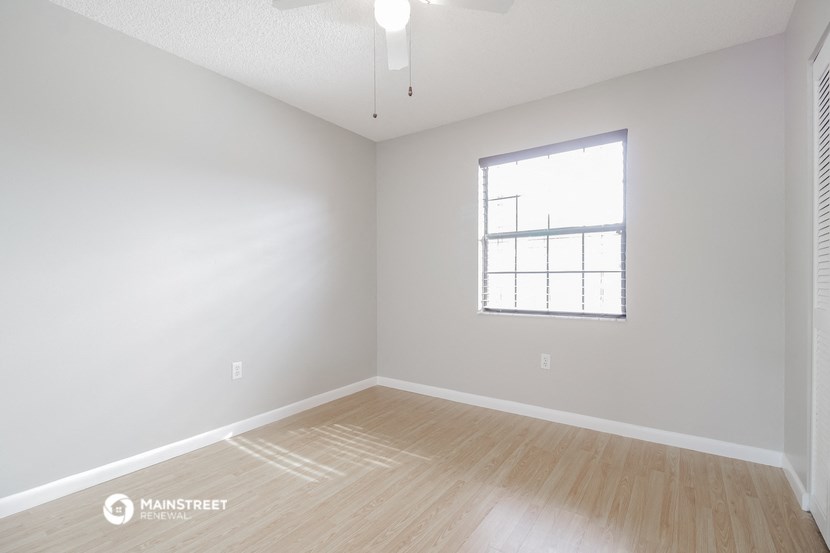 a spacious living room with hardwood floors and a window