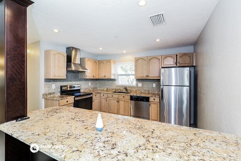 a kitchen with a large granite counter top and stainless steel appliances