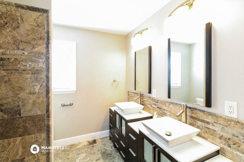 a bathroom with two sinks and a shower and a mirror