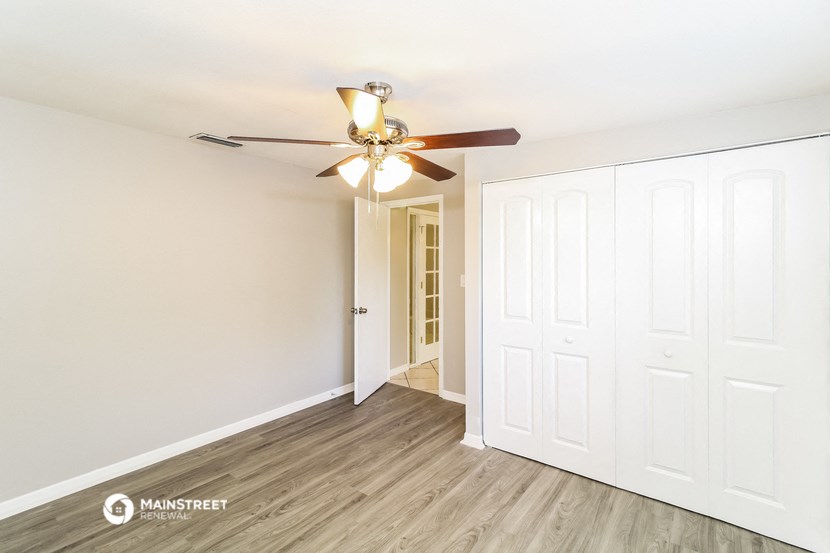 a bedroom with two closets and a ceiling fan