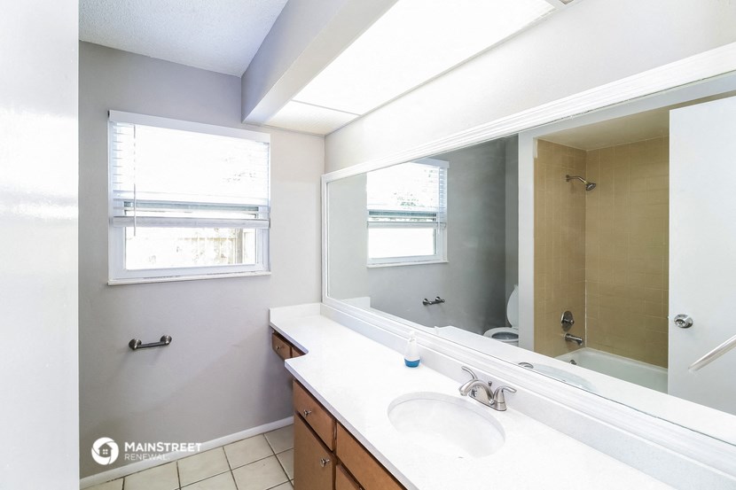 a bathroom with a large mirror and a sink and a shower