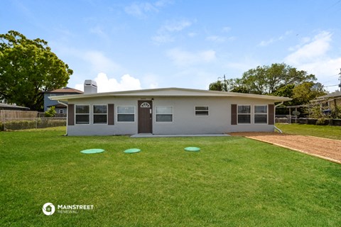 a small white house with a yard and a lawn