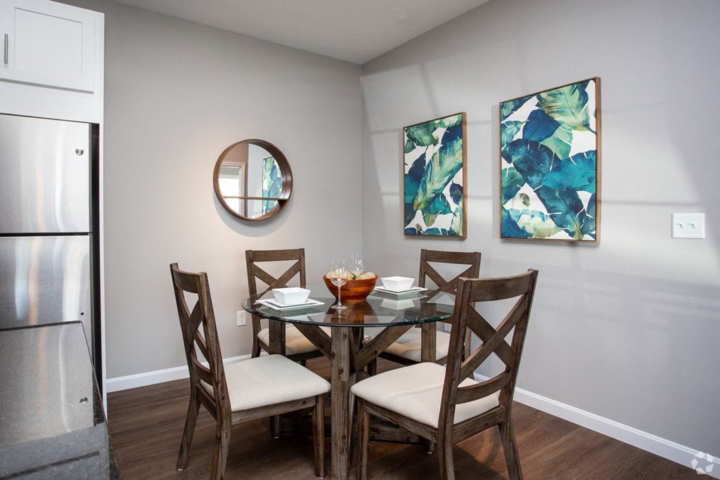 a dining room with a table and chairs and paintings on the wall