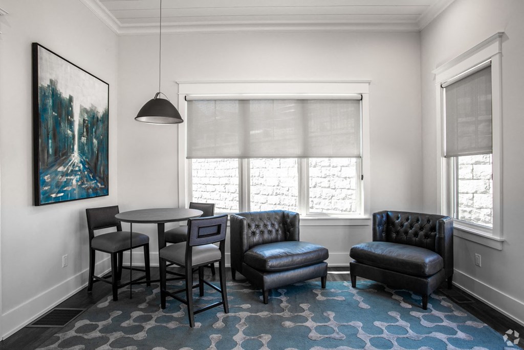 a living room with a table and chairs and a large window