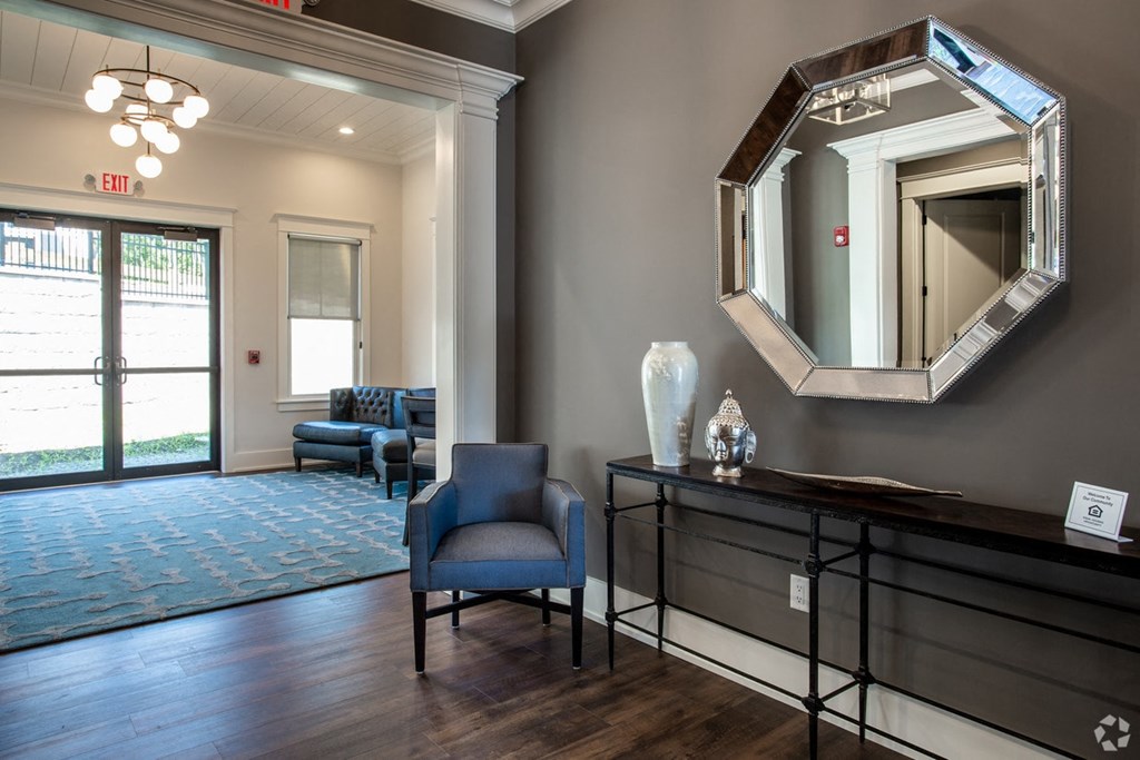 a living room with a mirror and a table with a blue chair