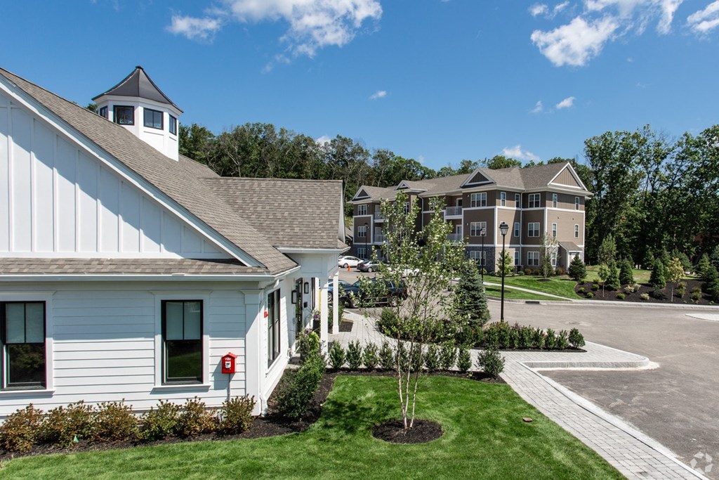 a view of a building and a yard with grass and trees