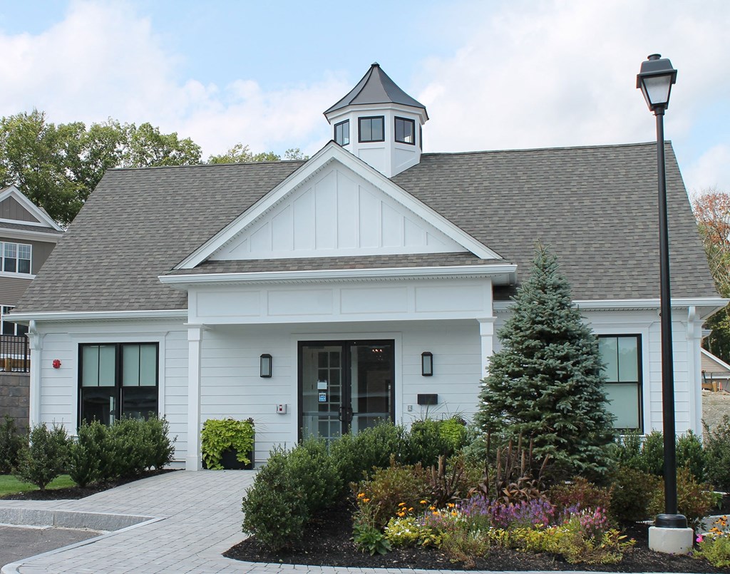 the front of a white building with a tree and a street light