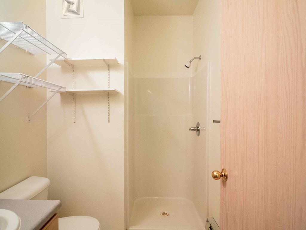 a bathroom with a shower and a sink and a toilet