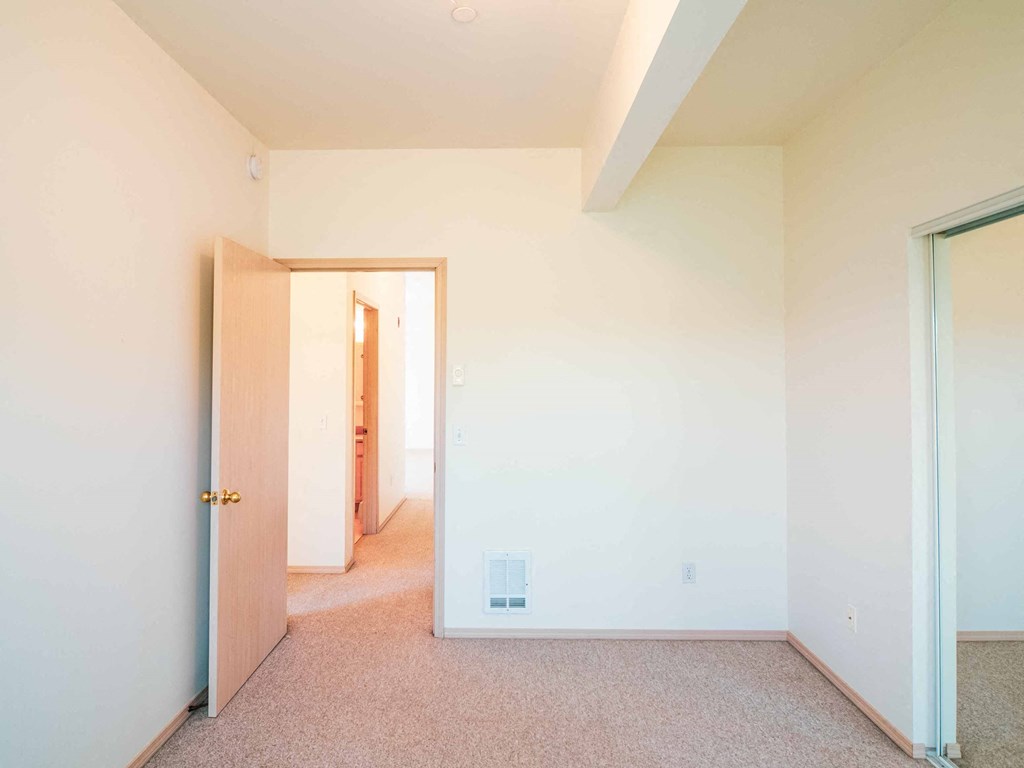 a bedroom with a closet and a door to a hallway