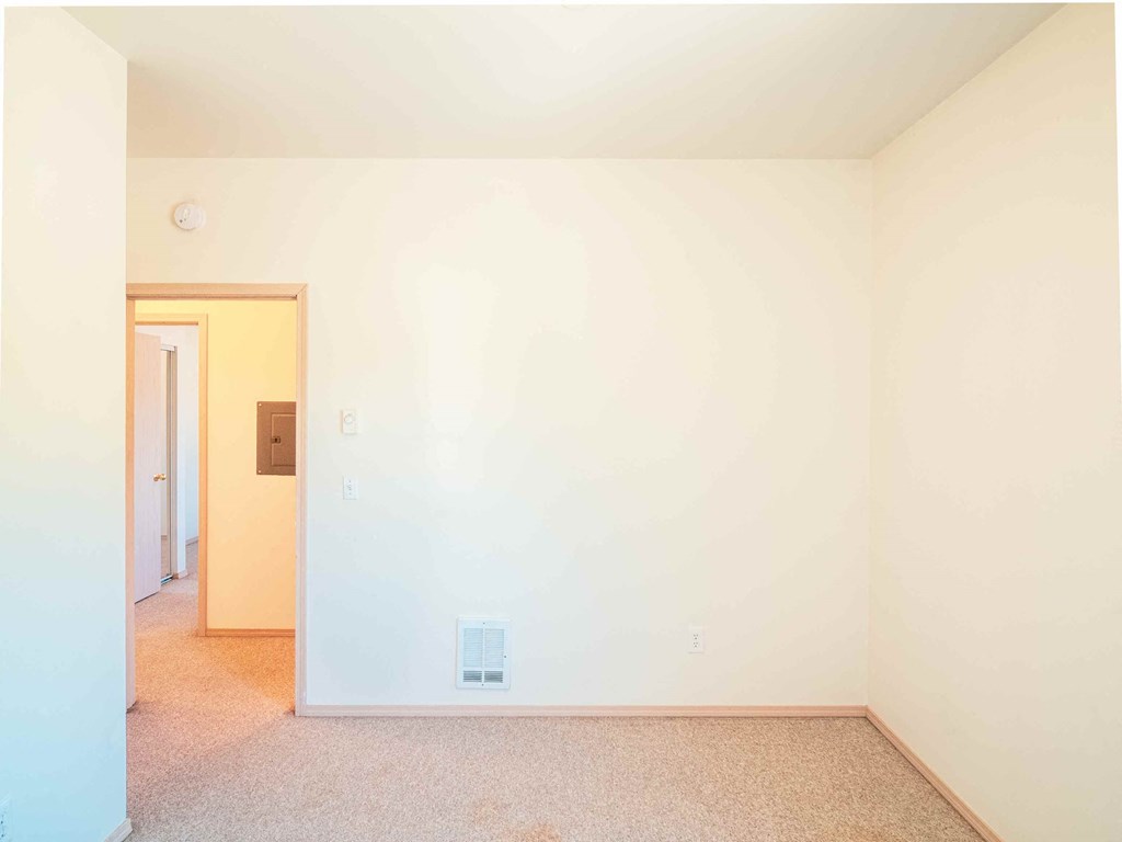 an empty room with white walls and a door