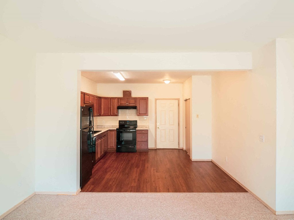 a view of a kitchen and living room with wood floors