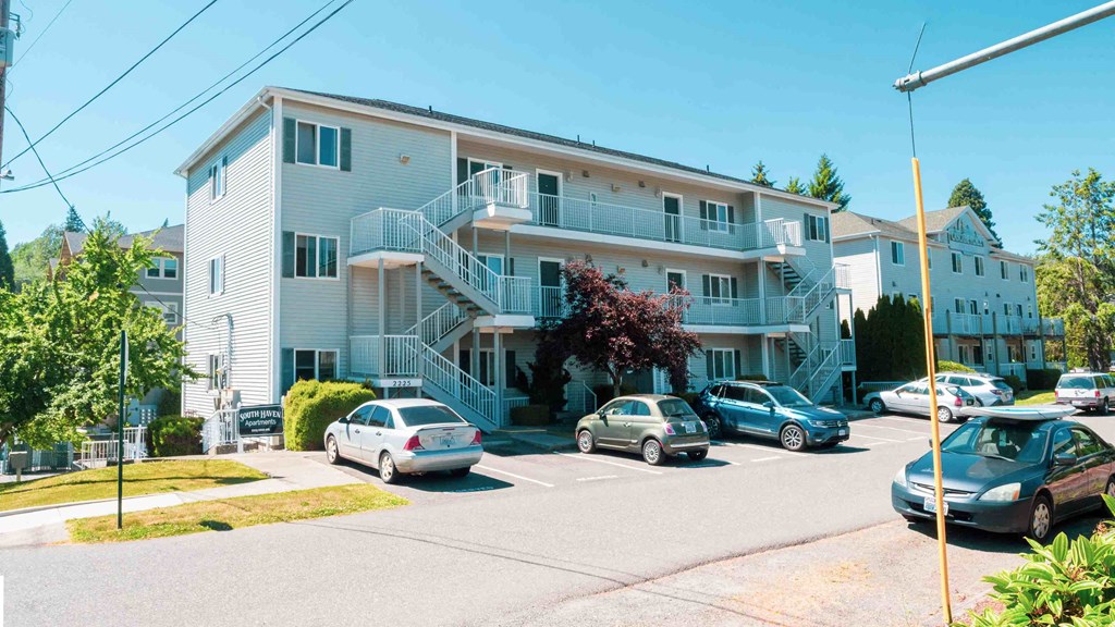 an apartment building with cars parked in front of it