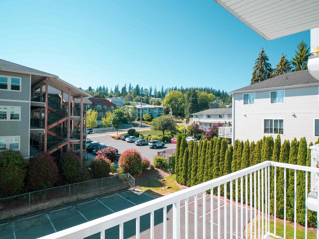 a balcony with a view of a house and a parking lot