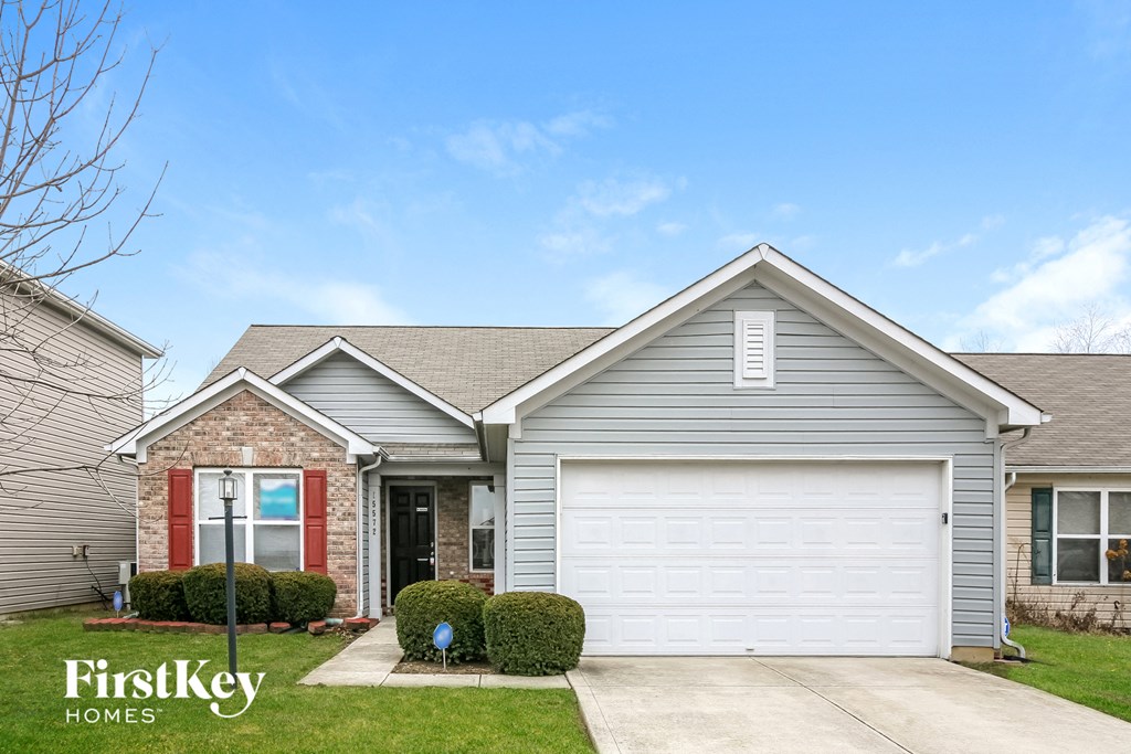 a home with a white garage door and a brick house