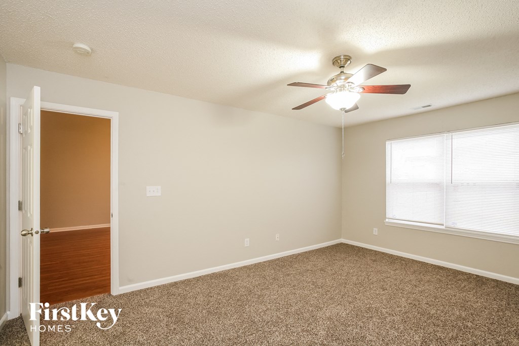 a bedroom with a ceiling fan and a window