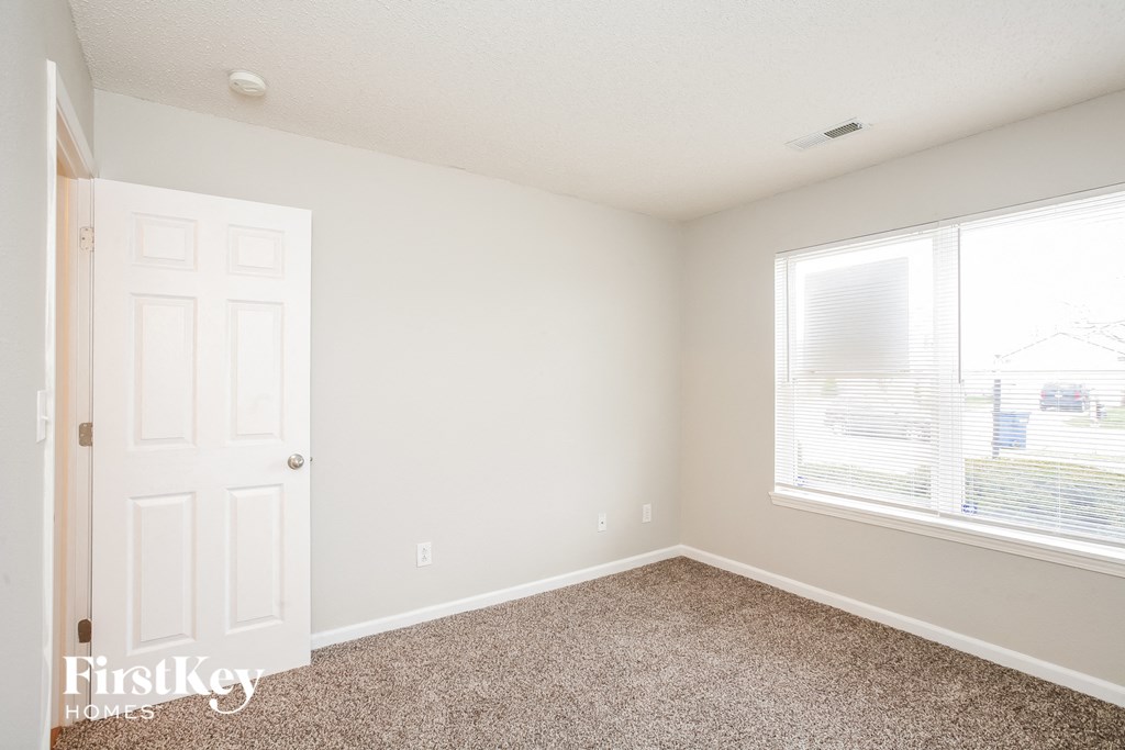 a bedroom with a white door and a window