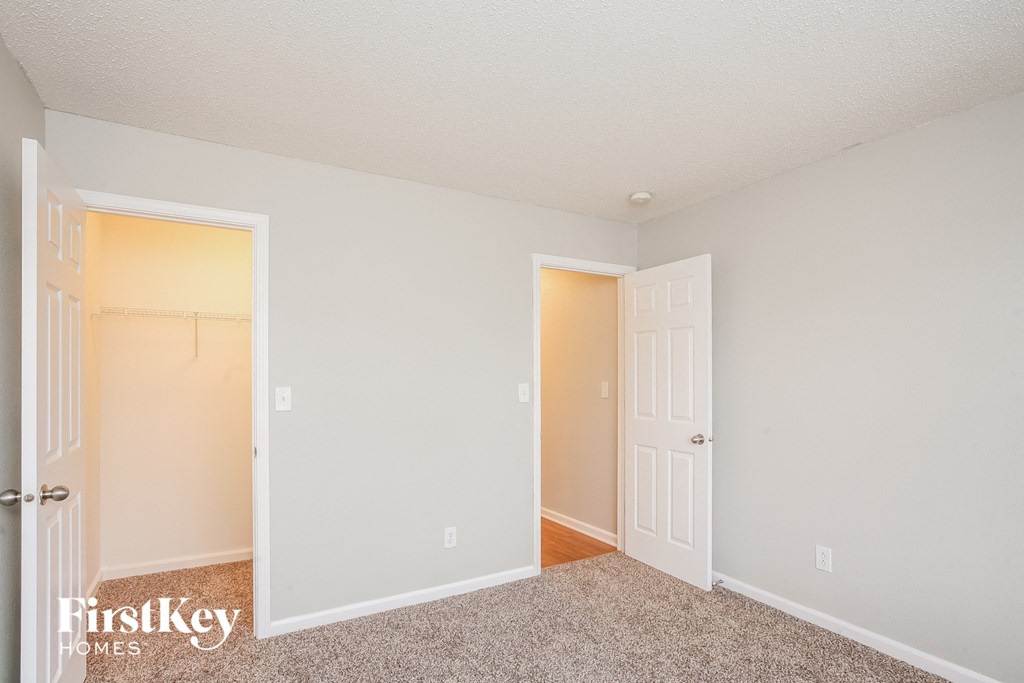 a bedroom with a door to a closet and a door into a closet