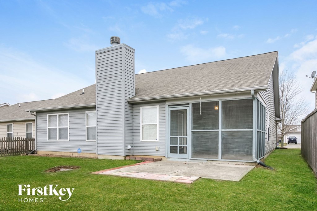 a gray house with a porch and a lawn