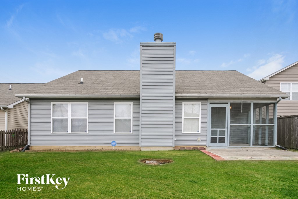 a gray house with a yard in front of it