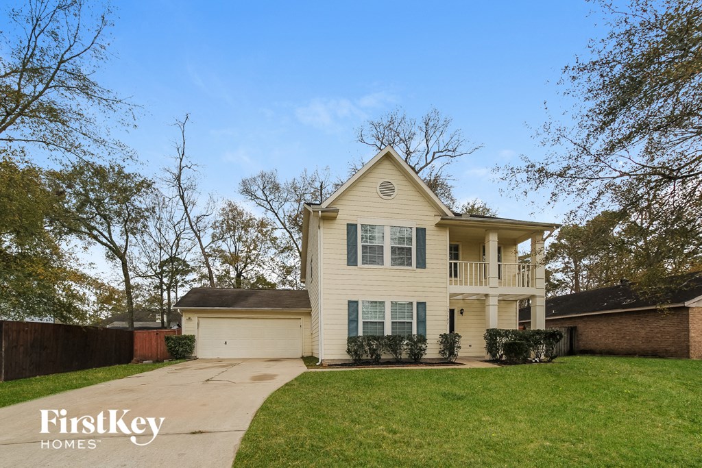 a beige house with a lawn and a sidewalk