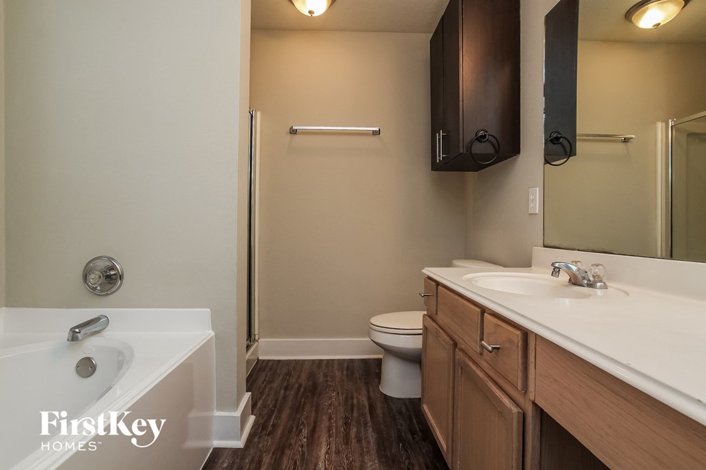 a bathroom with a toilet sink and shower and a tub