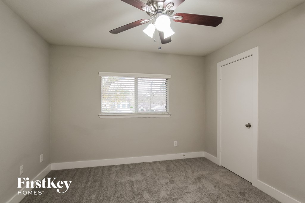 a bedroom with a ceiling fan and a window