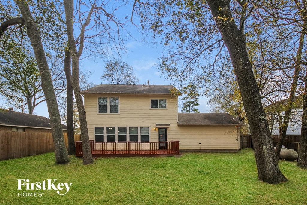 a yellow house with a yard and a fence