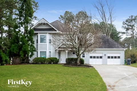 a white house with a lawn and a white garage door