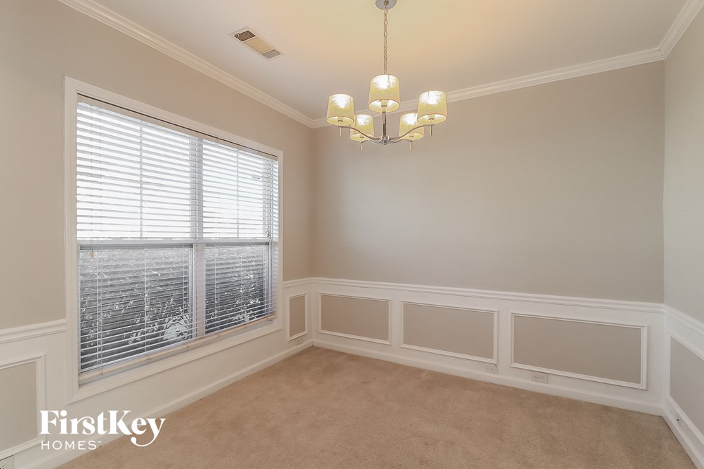 a dining room with a large window and a chandelier