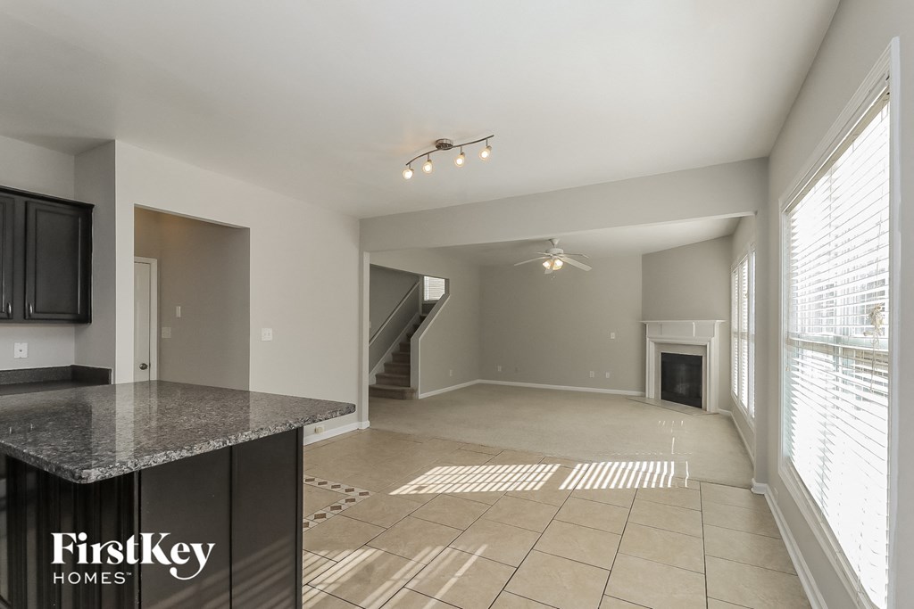 a kitchen and living room with a fireplace and tile flooring