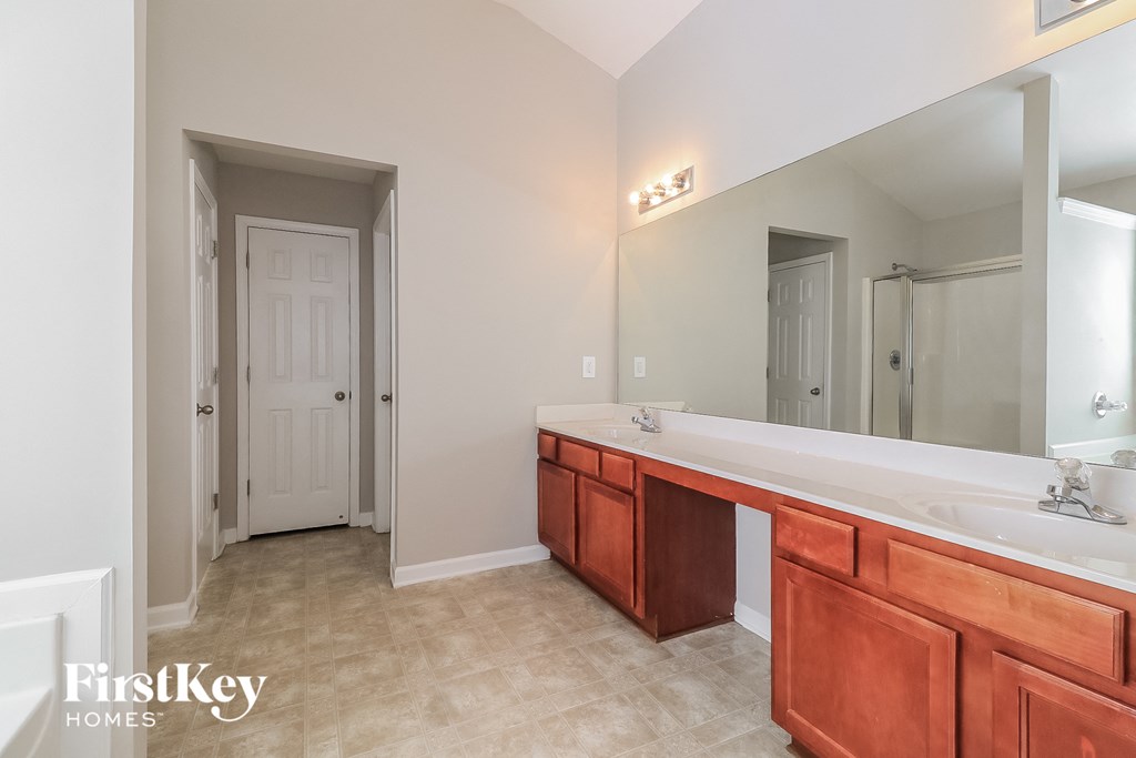 a master bathroom with a large vanity and a large mirror