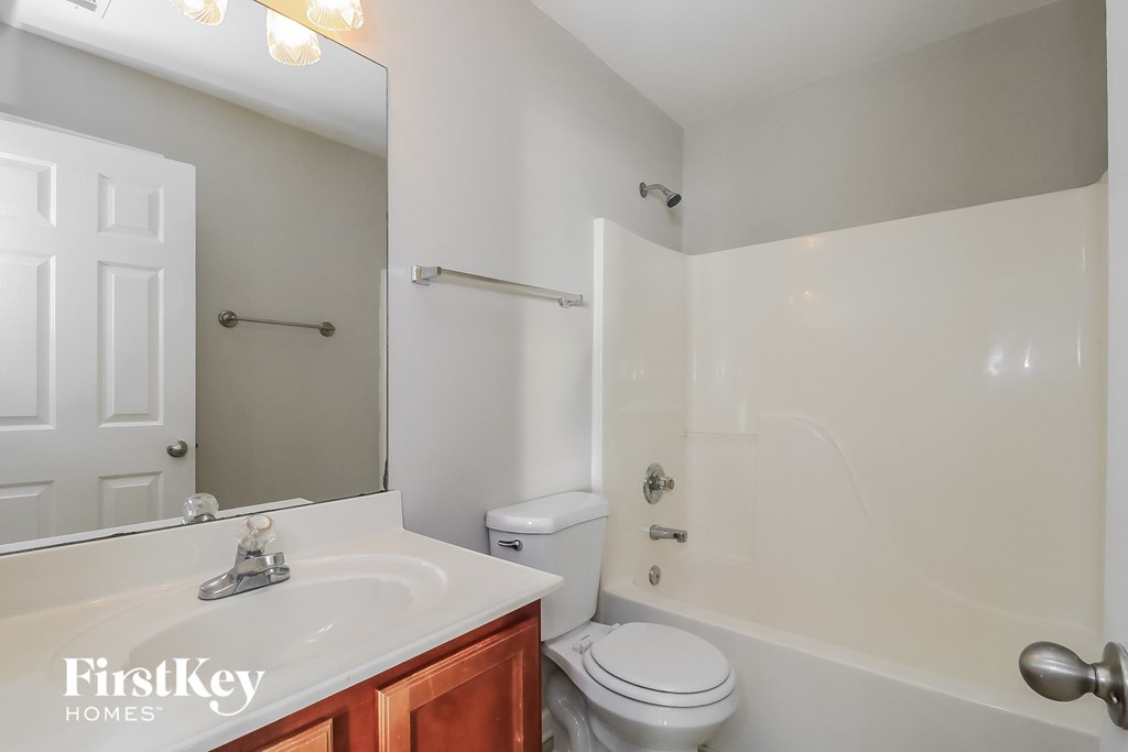 a bathroom with a sink toilet and a mirror