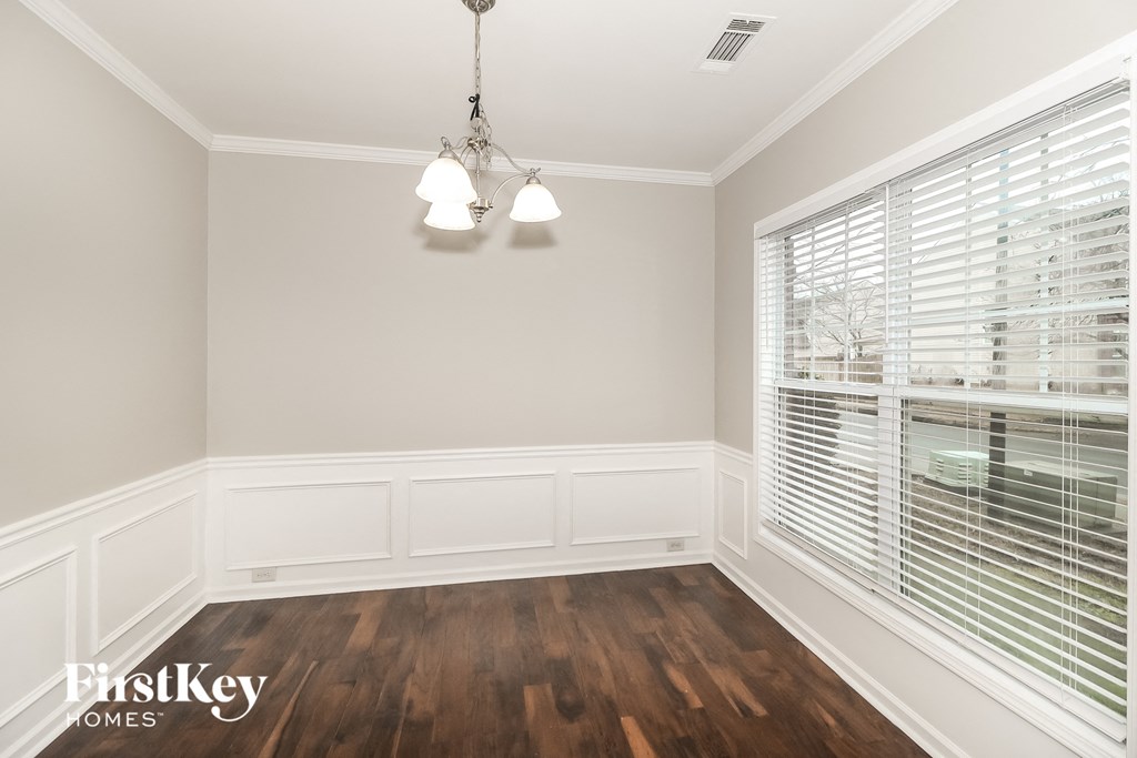 A room with wooden floors and a chandelier.