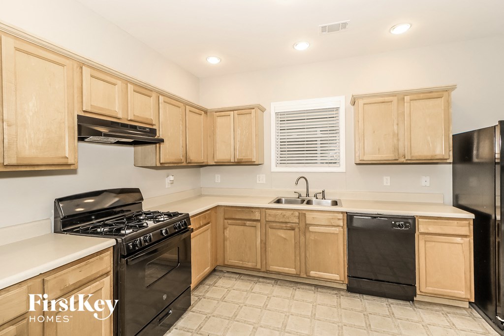 A kitchen with wooden cabinets and black appliances.
