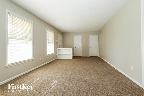 a spacious living room with carpeted floors and a large window
