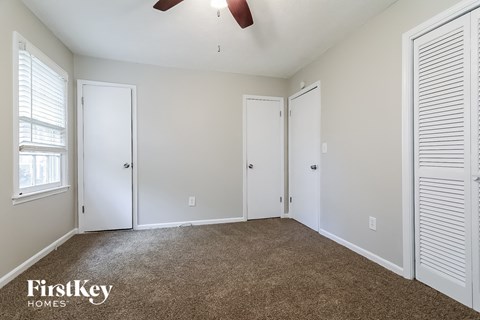 a bedroom with a carpeted floor and white doors