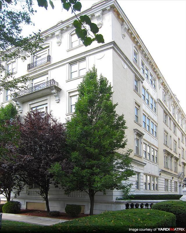 a large white building with a tree in front of it